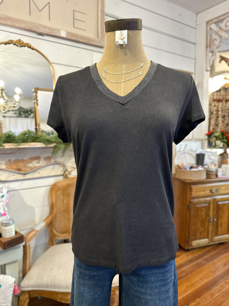 Mannequin wearing a dark gray V-neck t-shirt with blue jeans in a store setting.
