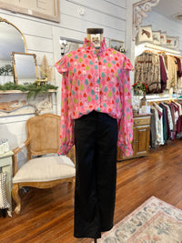 Pink floral blouse on a mannequin in a store setting with clothing racks and decor. christmas tree design 