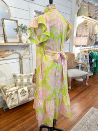 Floral dress on a mannequin in a store setting with various items in the background.