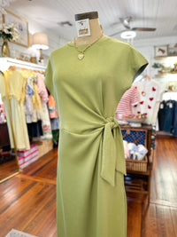 Green dress on a mannequin in a store setting