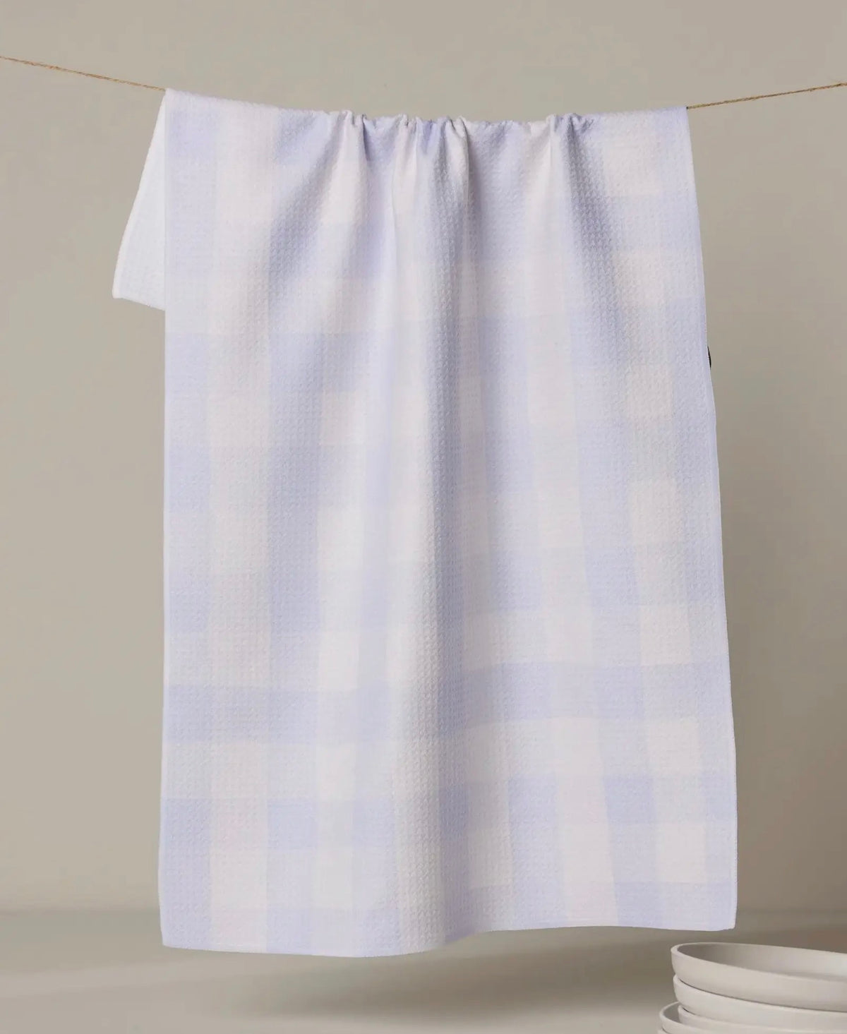 light purple pattern towel hanging on a line against a beige background