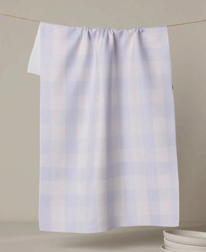 light purple pattern towel hanging on a line against a beige background