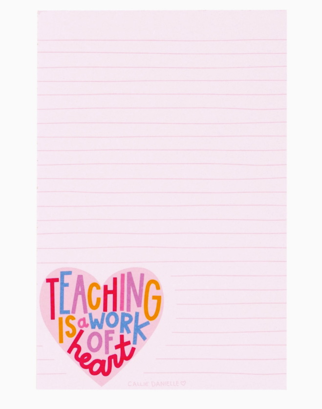 Notebook with 'Teaching is a work of heart' text in colorful letters on a pink background