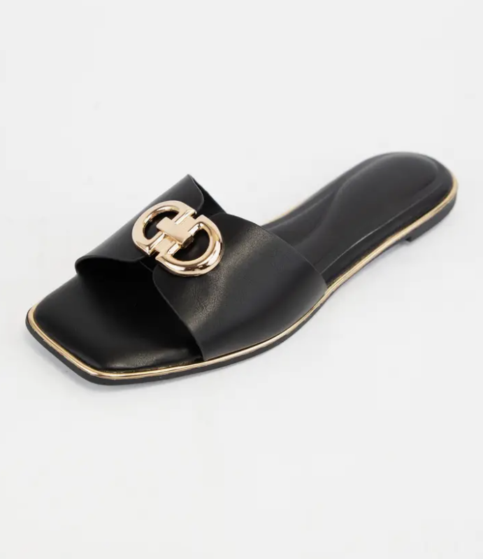Black slide sandal with gold buckle on a white background