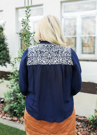 Person wearing a navy blue jacket with a patterned back panel outdoors.
LAYERZ CLOTHING JANE TOP