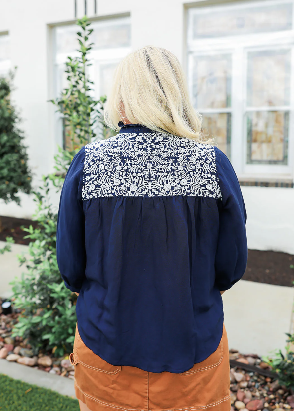 Person wearing a navy blue jacket with a patterned back panel outdoors.
LAYERZ CLOTHING JANE TOP