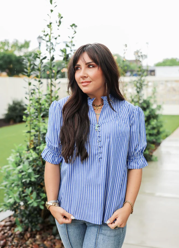 Woman wearing a blue striped shirt standing outdoors with greenery in the background
LAYERZ CLOTHING LAUREN TOP 