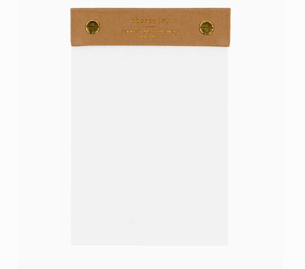 White notepad with a brown canvas cover on a white background