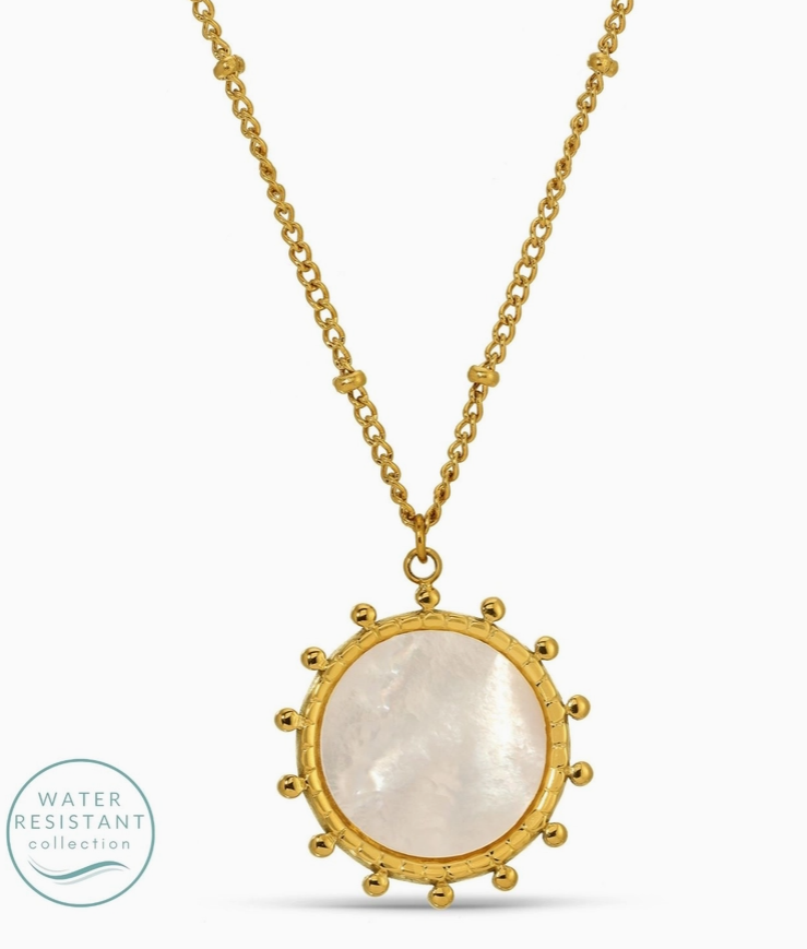 Gold necklace with a round pendant on a white background