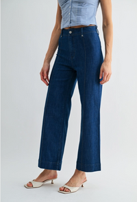 Person wearing blue wide-leg jeans on a light gray background