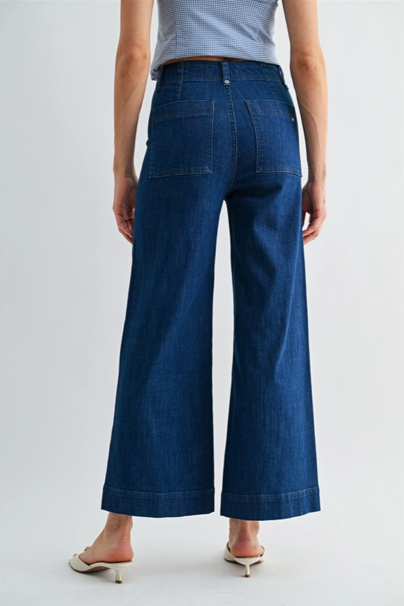 Person wearing blue wide-leg jeans on a plain background