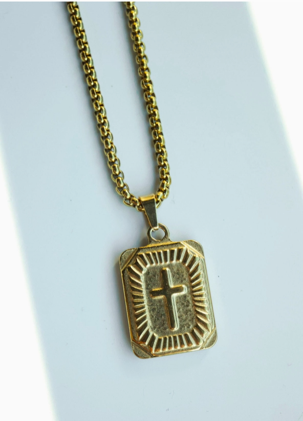 Gold necklace with a rectangular pendant featuring a cross on a light blue background