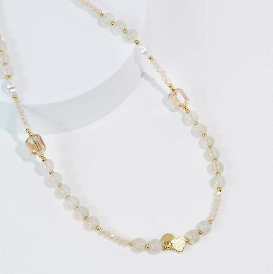 Necklace with white beads and gold accents on a white background