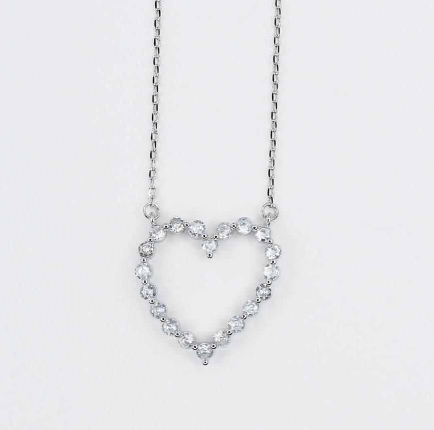 Heart-shaped necklace with clear stones on a light gray background