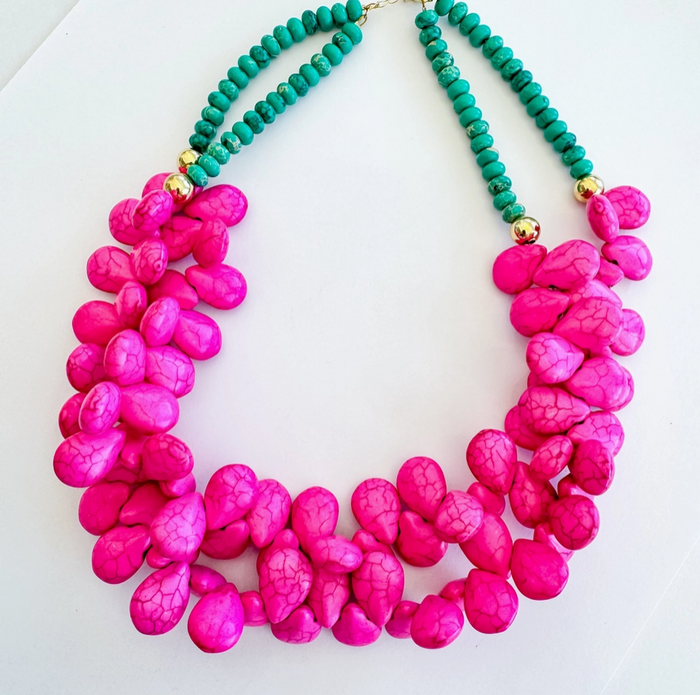 Necklace with pink and turquoise beads on a white background