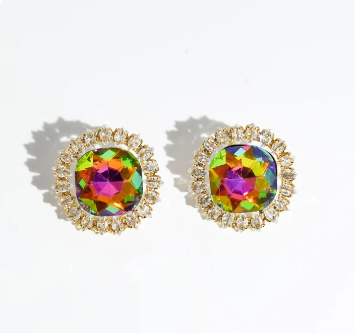 A pair of gold-toned stud earrings with round iridescent faceted center stones and small clear surrounding stones, photographed on a white background with soft shadows.