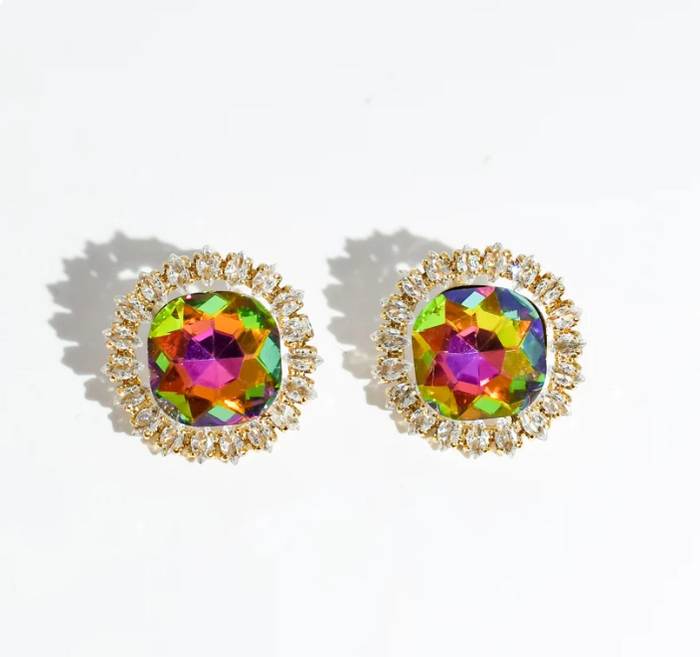 A pair of gold-toned stud earrings with round iridescent faceted center stones and small clear surrounding stones, photographed on a white background with soft shadows.