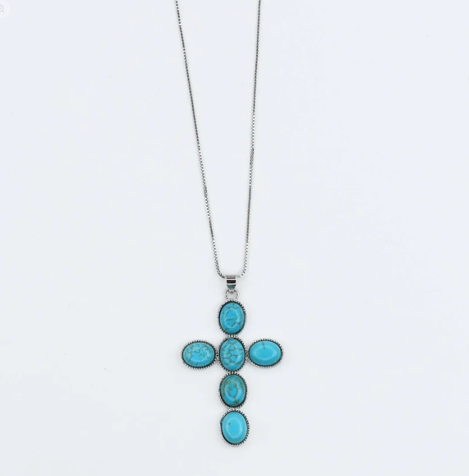 A silver cross pendant necklace featuring five oval turquoise-blue stones, displayed against a plain white background.