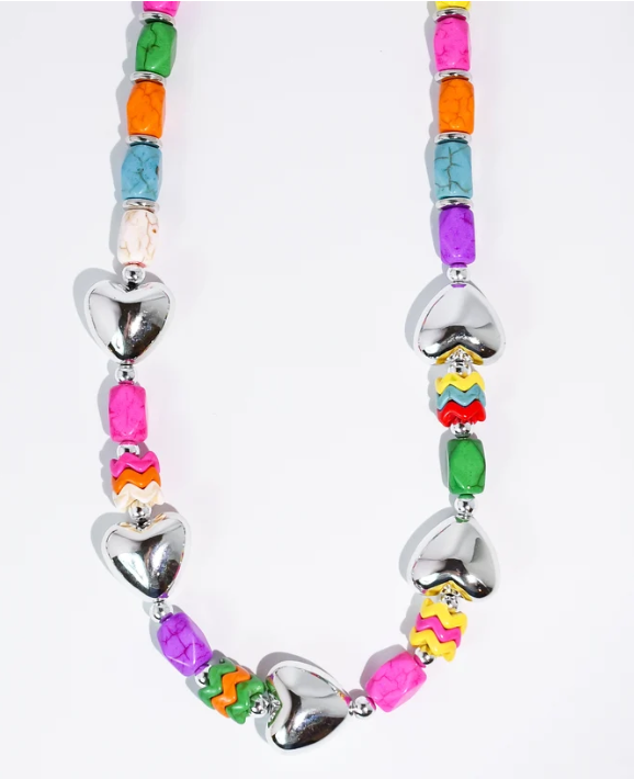 A colorful beaded necklace featuring large silver heart charms and vibrant, patterned rectangular beads in pink, orange, green, blue, purple, and yellow on a white background.