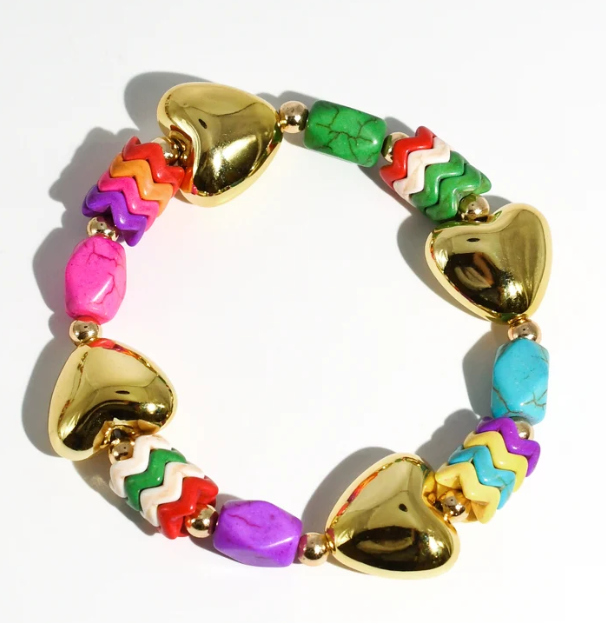 A colorful beaded stretch bracelet with shiny gold heart-shaped beads and multi-colored chevron and stone beads in pink, green, red, purple, and blue, displayed on a clean white background.