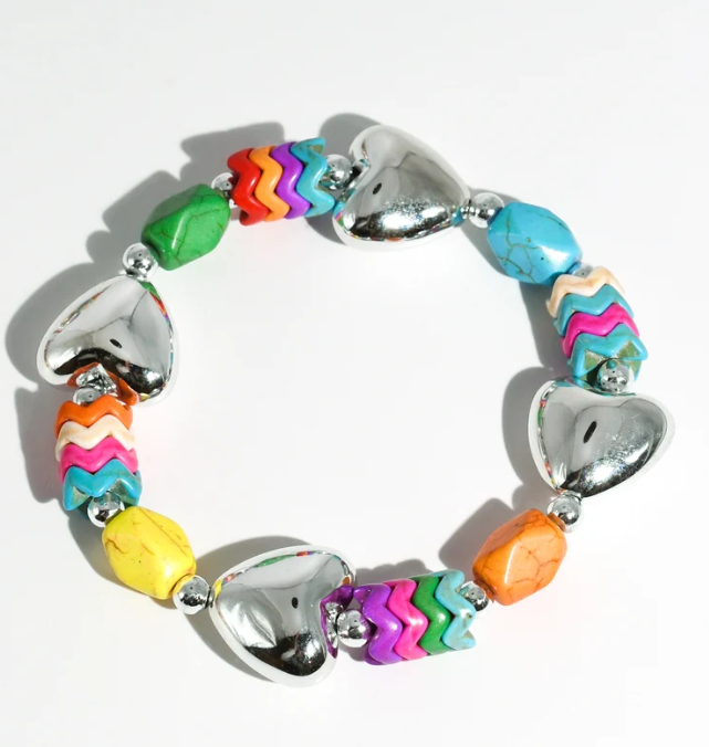 A colorful beaded bracelet with shiny silver heart-shaped beads and multi-colored chevron and textured beads, displayed on a clean white background.