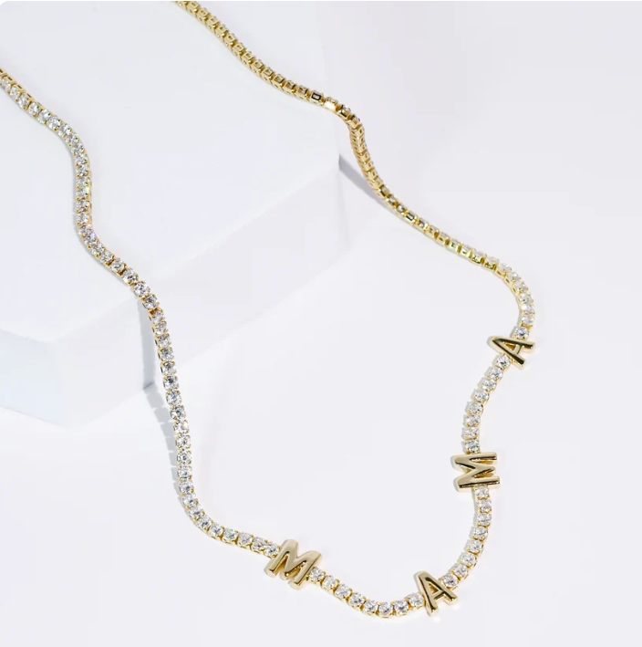 A gold chain necklace featuring clear rhinestones and alternating gold letters spelling 'MAMA', displayed on a clean white background.