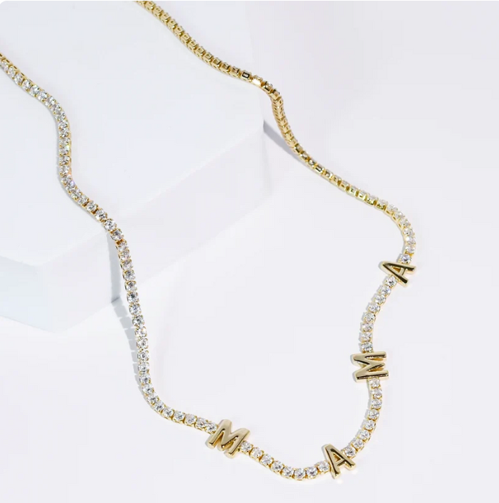A gold chain necklace featuring clear rhinestones and alternating gold letters spelling 'MAMA', displayed on a clean white background.