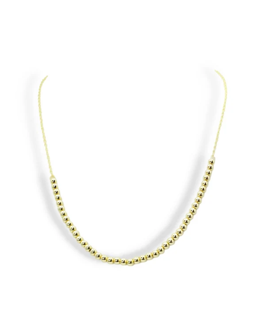 A delicate gold beaded necklace with a fine chain, displayed against a clean white background.