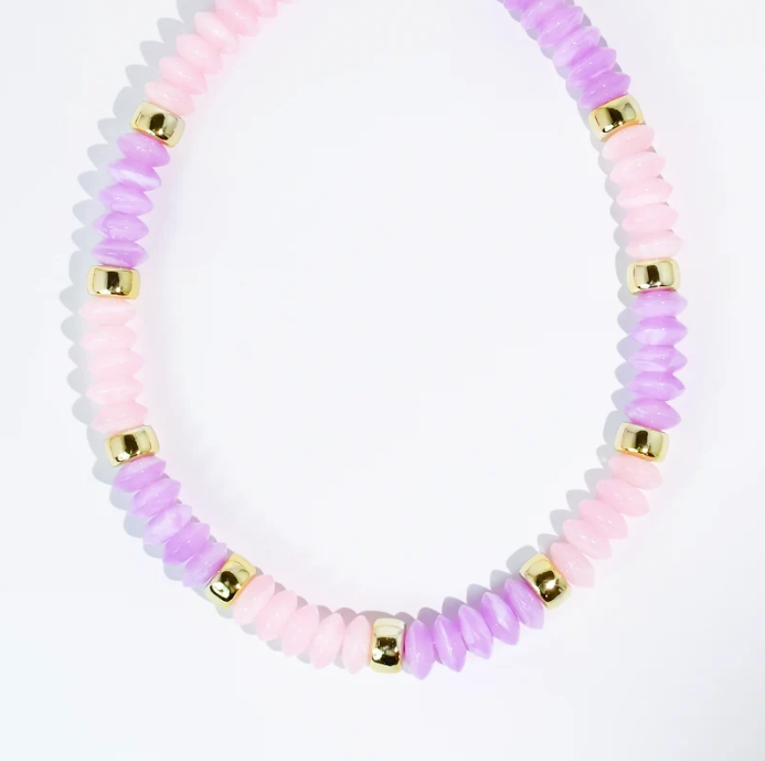 A beaded necklace featuring alternating strands of faceted light pink and lavender purple beads, separated by small shiny gold spacer beads, photographed on a clean white background.