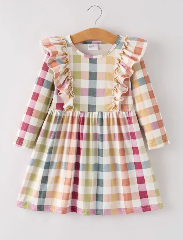 A toddler girl's long-sleeve dress with a pastel multicolor gingham plaid pattern, featuring ruffle trim along the neckline and shoulders, hanging on a wooden hanger against a light gray background.