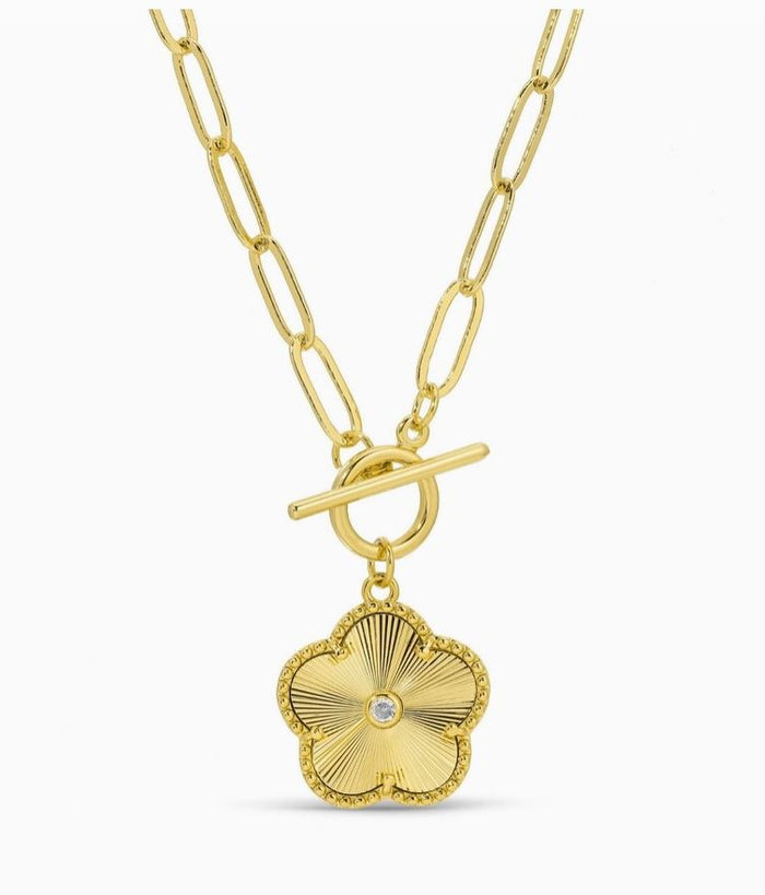 Gold necklace with a flower-shaped pendant on a white background