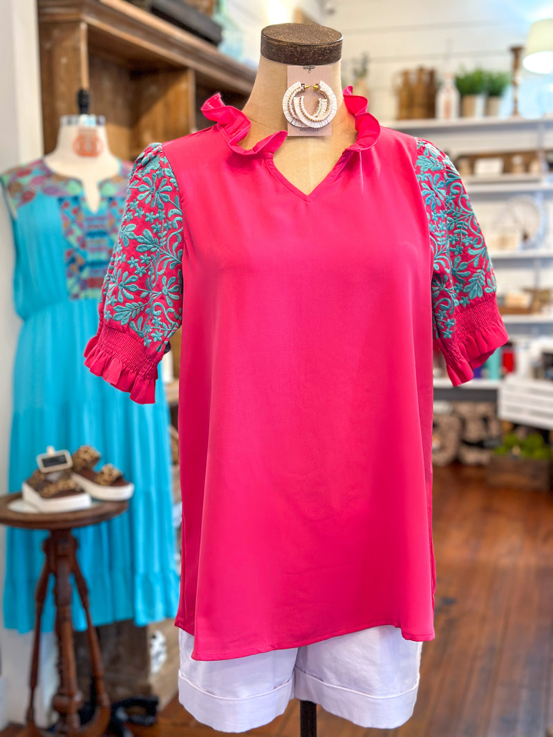 hot pink top with ruffle neckline turquoise embroidery detail on sleeves