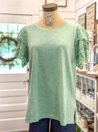 light green top with eyelet lace details on sleeves