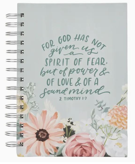 Notebook with floral design and inspirational quote on a light gray background