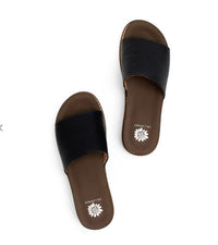 Pair of black sandals with brown soles on a white background