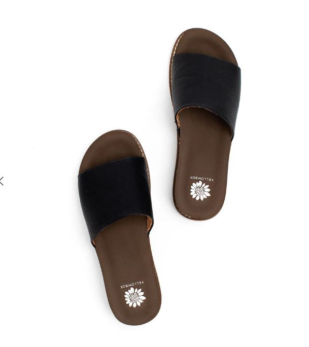 Pair of black sandals with brown soles on a white background