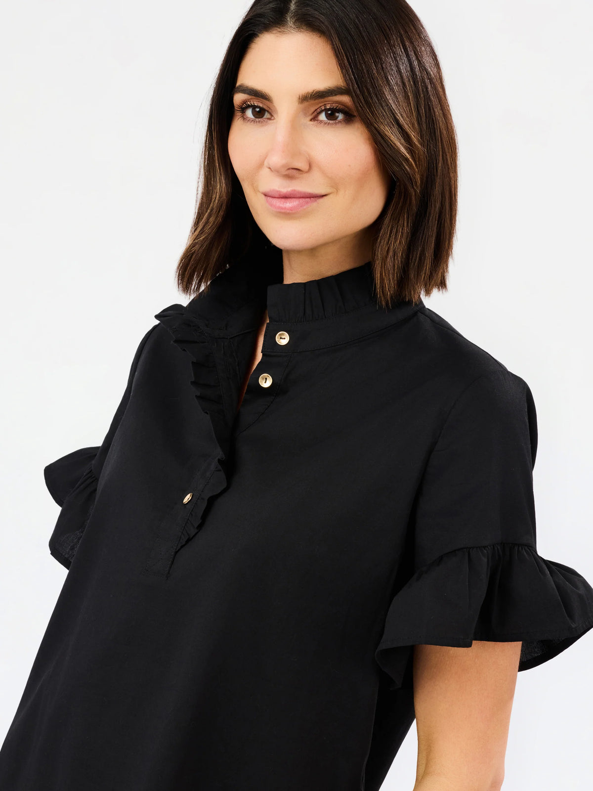up close solid black blouse with ruffle details on sleeves and neckline and collar on white background 

