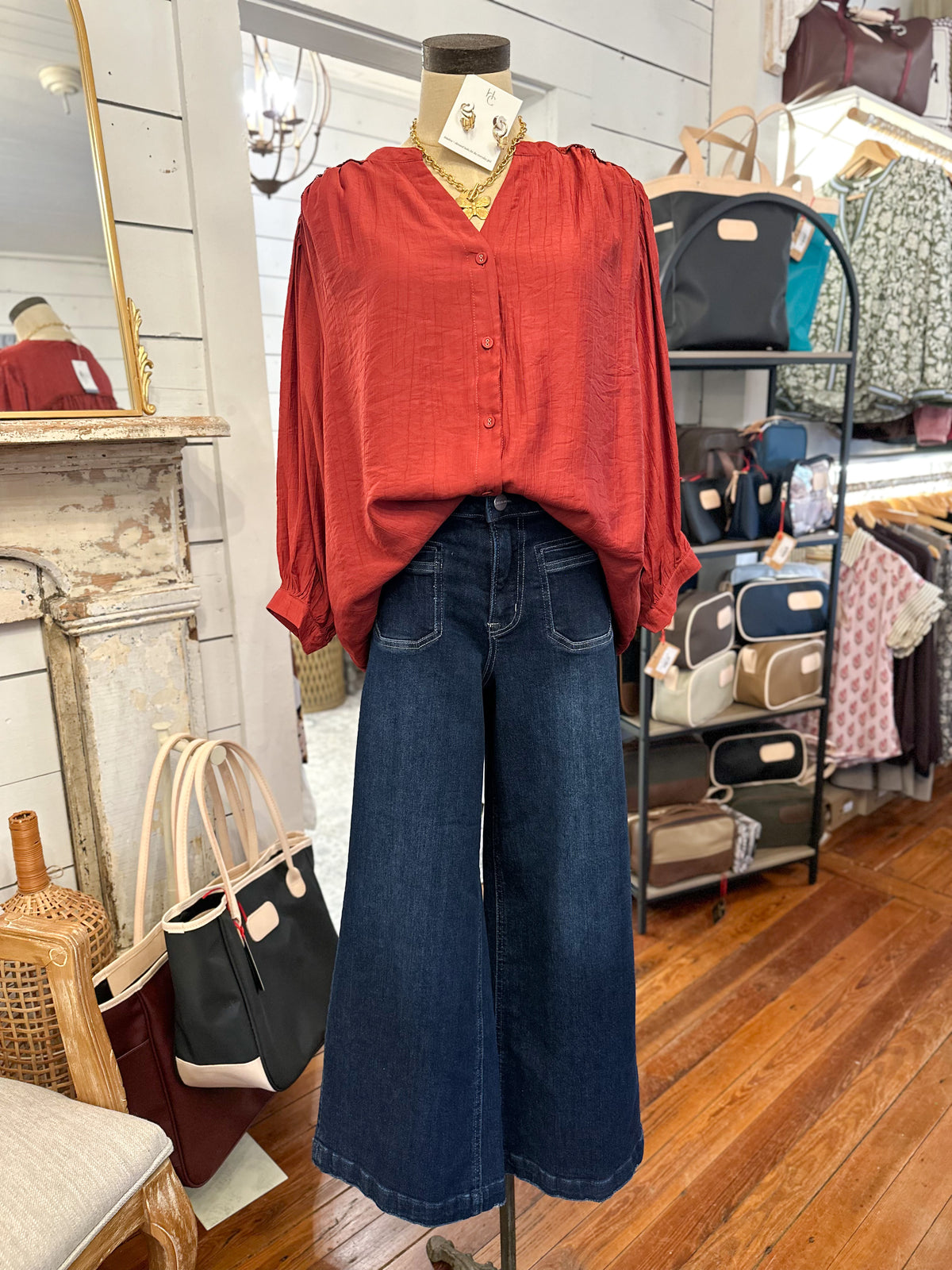 rust color blouse umgee brand inside store setting with jeans 