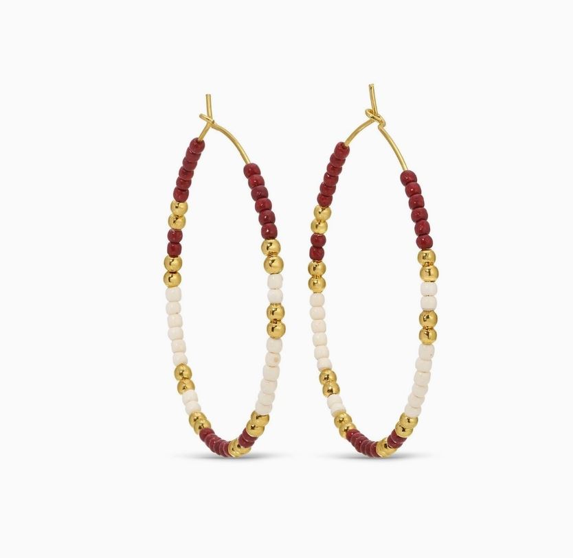 Hoop earrings with maroon, gold, and white beads on a white background