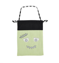Green bag with a face design on a white background mud pie treat bag 