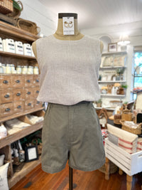 olive green high rise short with light tan tank top 
