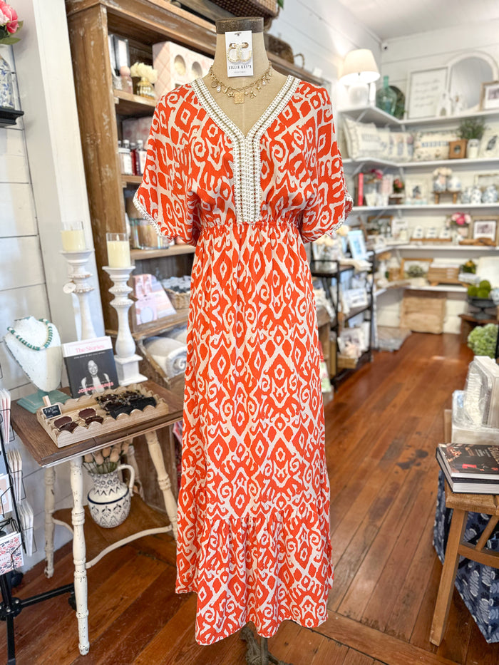 orange swirl print maxi dress with gold details on trim