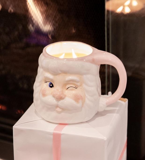 Ceramic mug shaped like a face with a candle inside, on a white box with a pink ribbon.