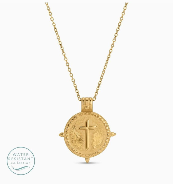 Gold necklace with a round pendant featuring a cross on a white background