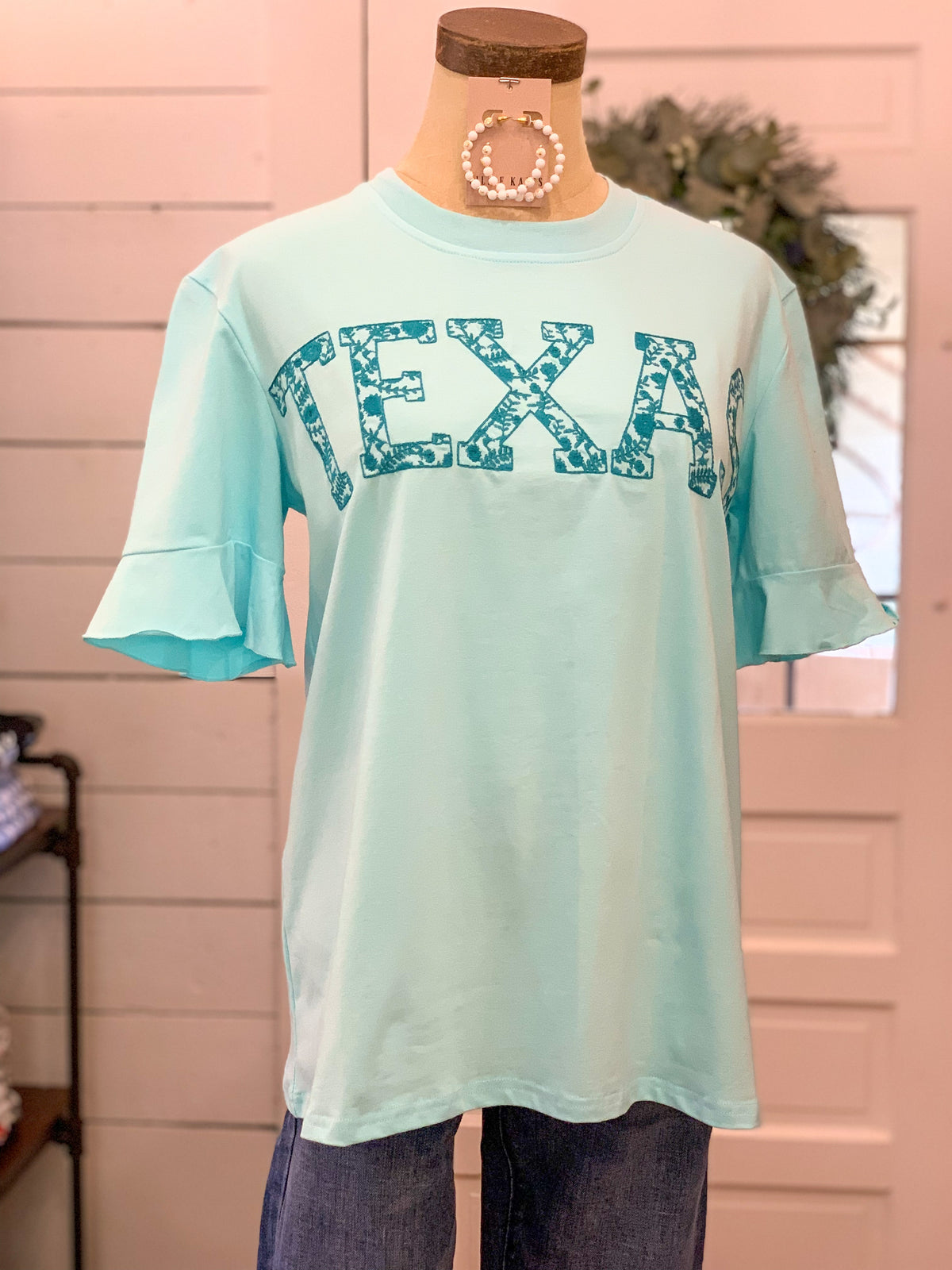 blue ruffle sleeve top that has texas emrbroidered 