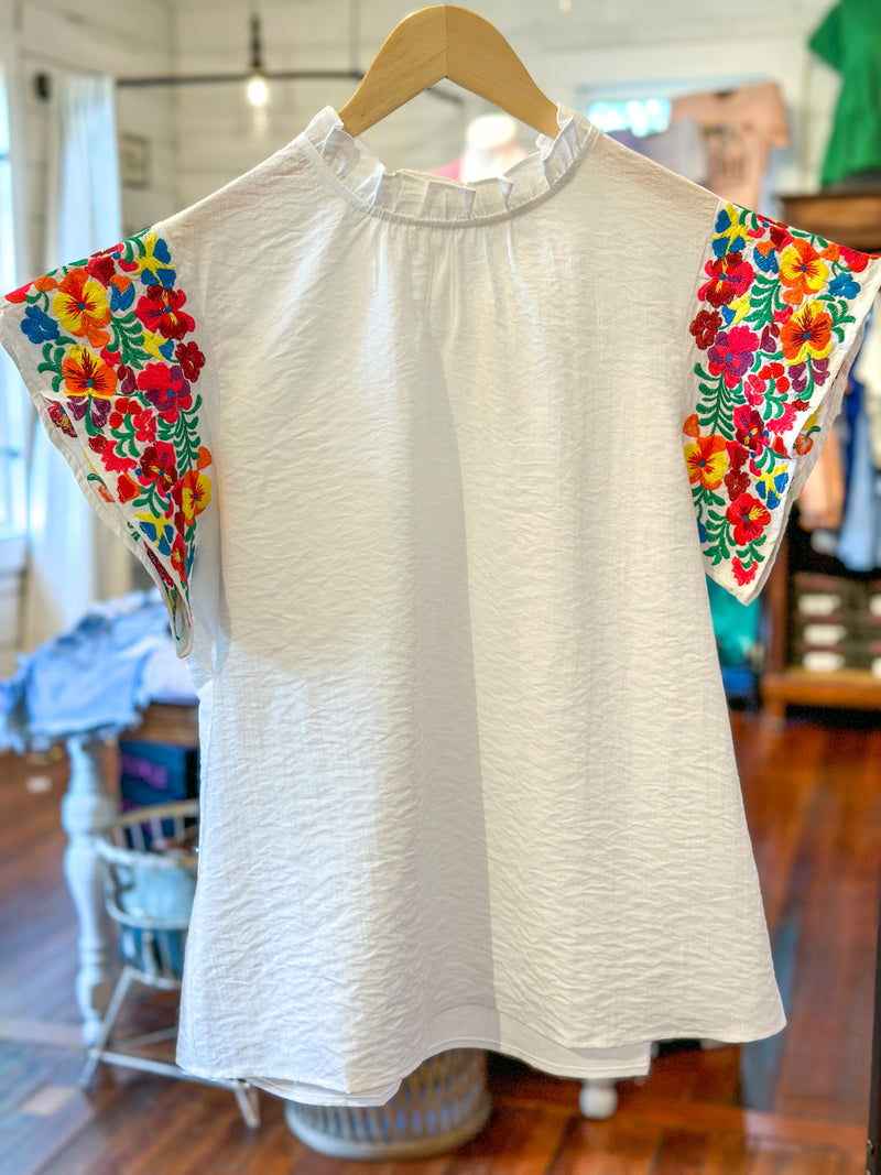 white top with colorful embroidered sleeves