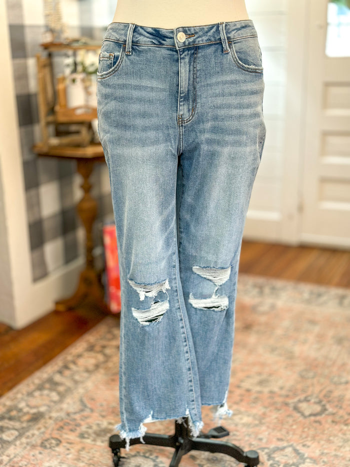 light wash vervet jean with distressing on the knee area and hem of jean